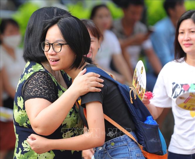 Người thân động viên thí sinh làm bài tốt tại điểm thi Trường THPT Đan Phượng. Ảnh: Hoàng Hiếu - TTXVN 